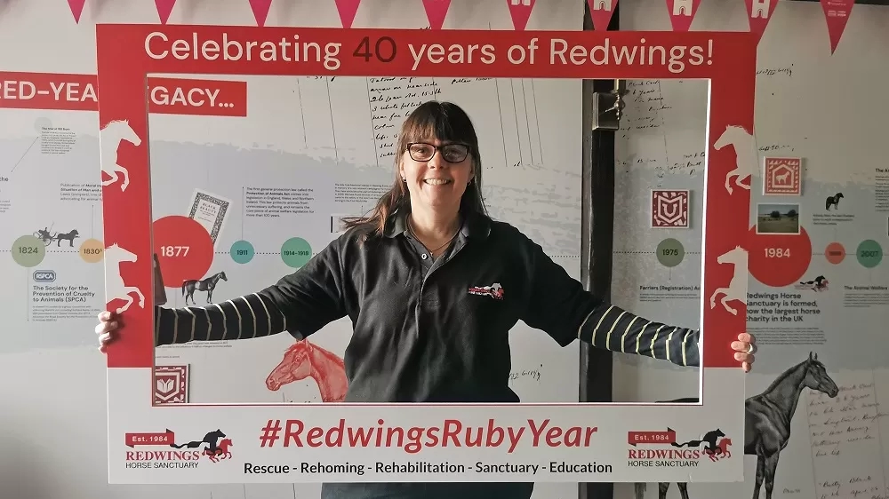 A Redwings staff member holds up a selfie frame at Anna Sewell House.