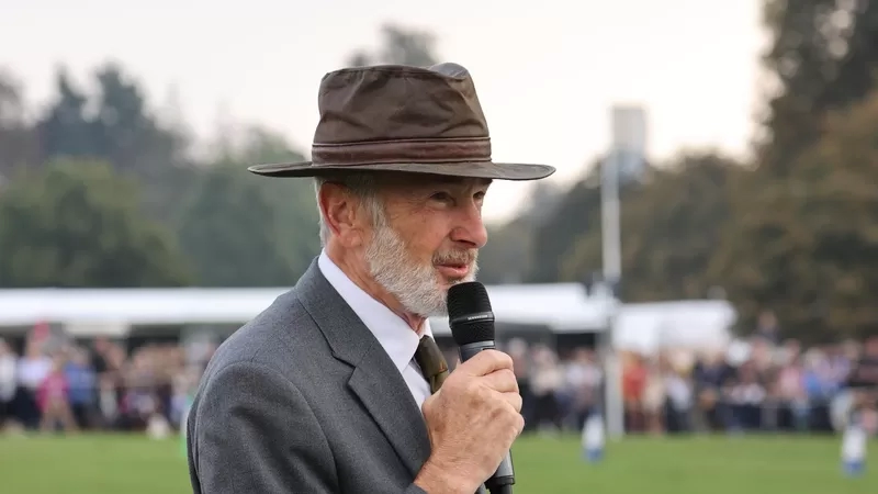 Trustee Ian is stood in an equestrian showing ring commentating 