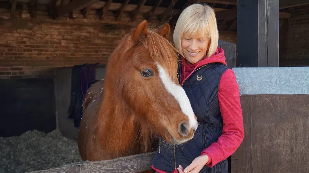 Photo of Nicola Jarvis with a chestnut pony.