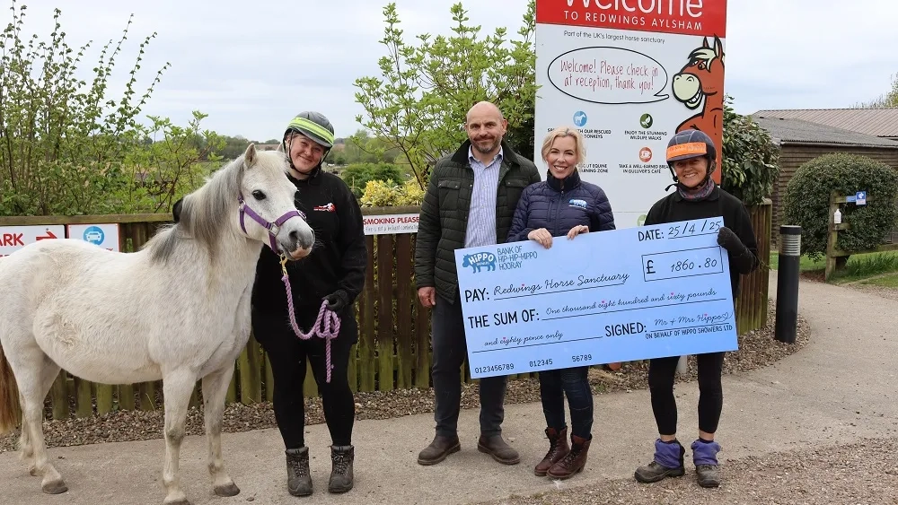 Poppy and husband Nick presenting a cheque