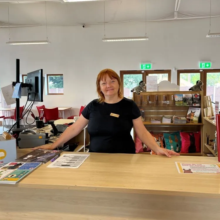 A person standing behind a Welcome Desk