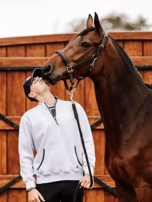 Showjumper Joe Stockdale stood next to his horse, who is kissing him